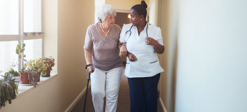 femme agée accompagnée par une infirmière vitesse de marche