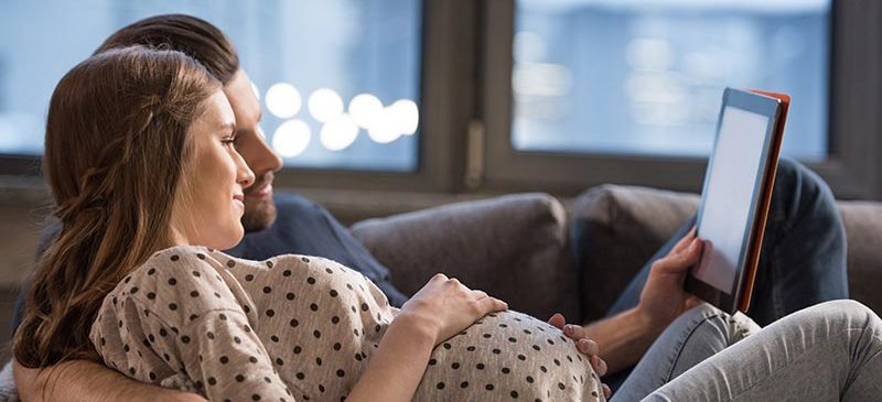 jeune couple regardant une tablette - bracelet connecté