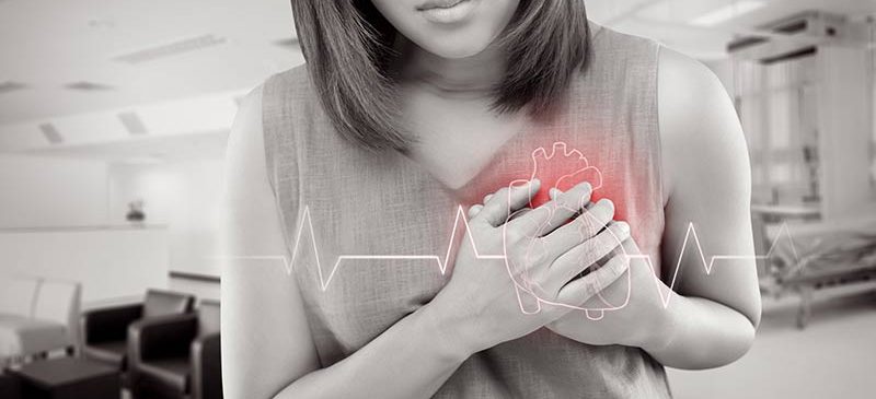 une femme se tient les mains sur le coeur, diclofénac risques cardiaques