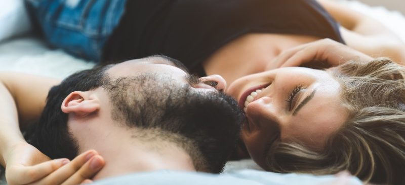 couple allongé sur un lit qui se regarde dans les yeux