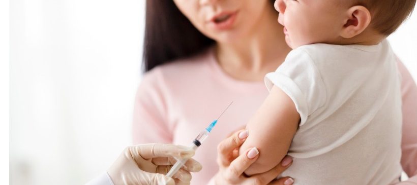 bébé se faisant vacciner dans les bras de sa mère