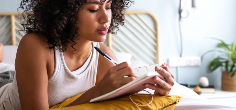 Header les bienfaits du journaling, femme écrivant dans un journal