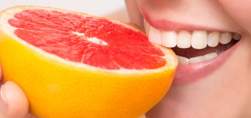 image article erosion dentaire et aliments acide - photo d'une dame croquant dans une orange